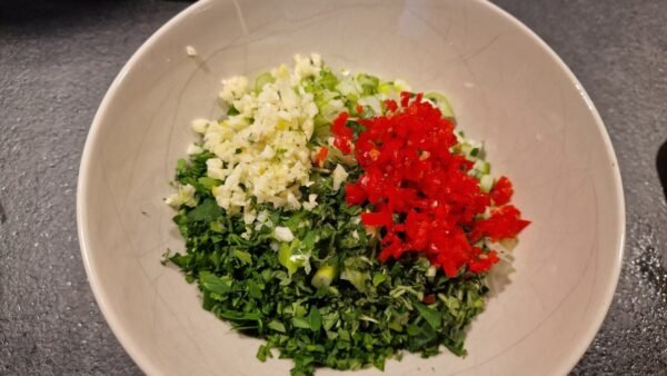 Finthakkede krydderurter, forårsløg, hvidløg og chili til chimichurri