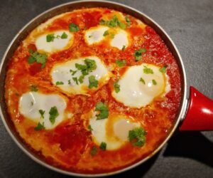 International shakshouka med pocherede æg i en pande