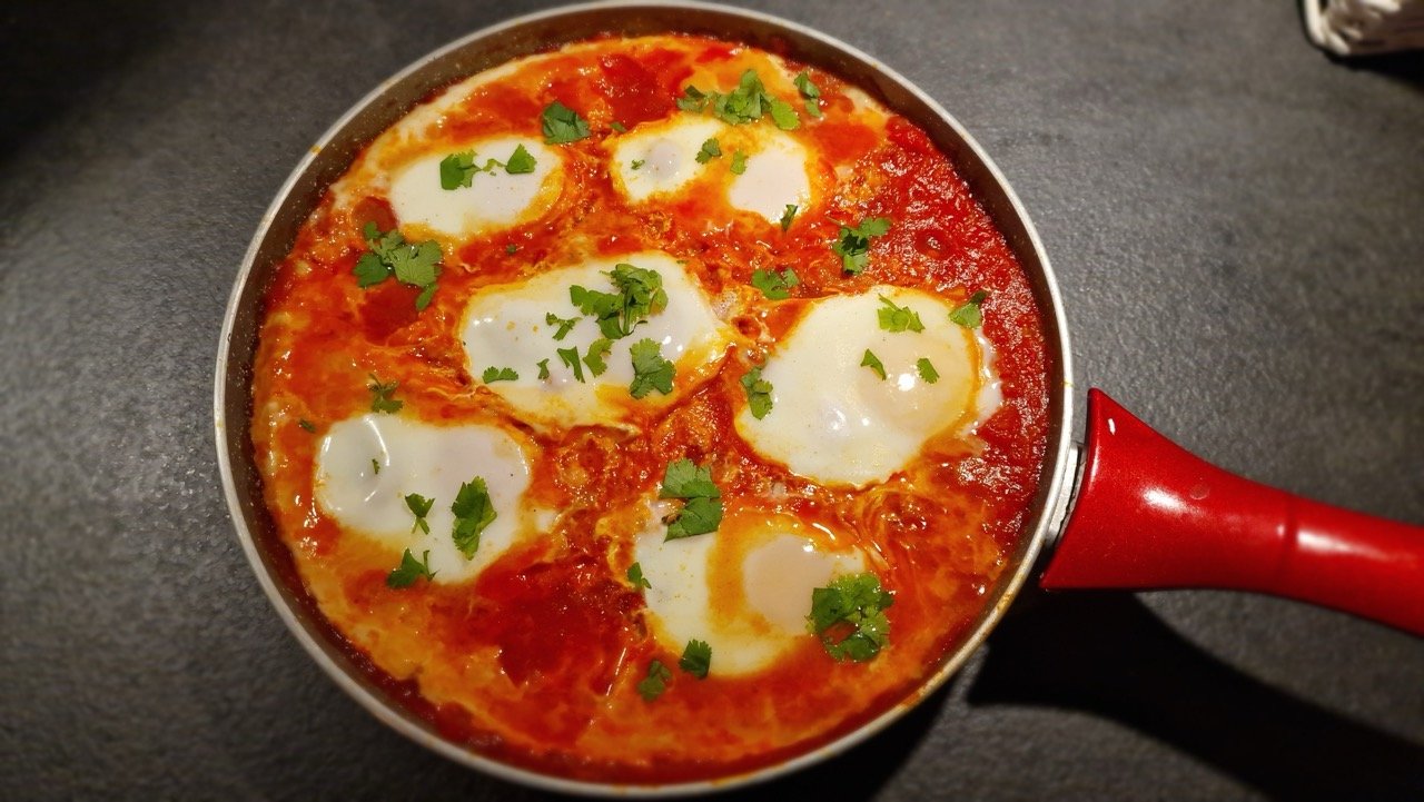 International shakshouka med pocherede æg i en pande