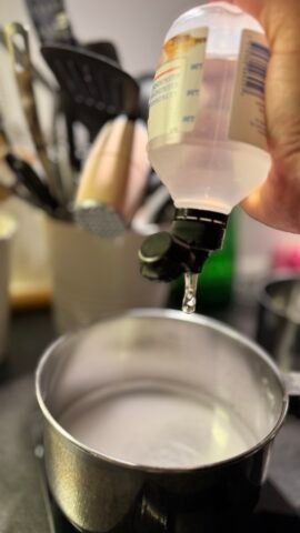 Glukosesirup hældes i en gryde til sukkerlagen